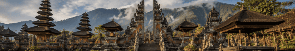 Balinese Hindu temple with tiered meru towers set against misty mountains