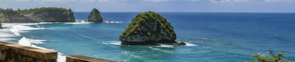 Cliffside viewpoint overlooking a green rock formation in a turquoise bay
