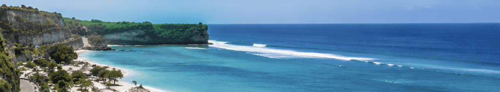Aerial view of a cliff-lined bay with turquoise water on Bali's south coast